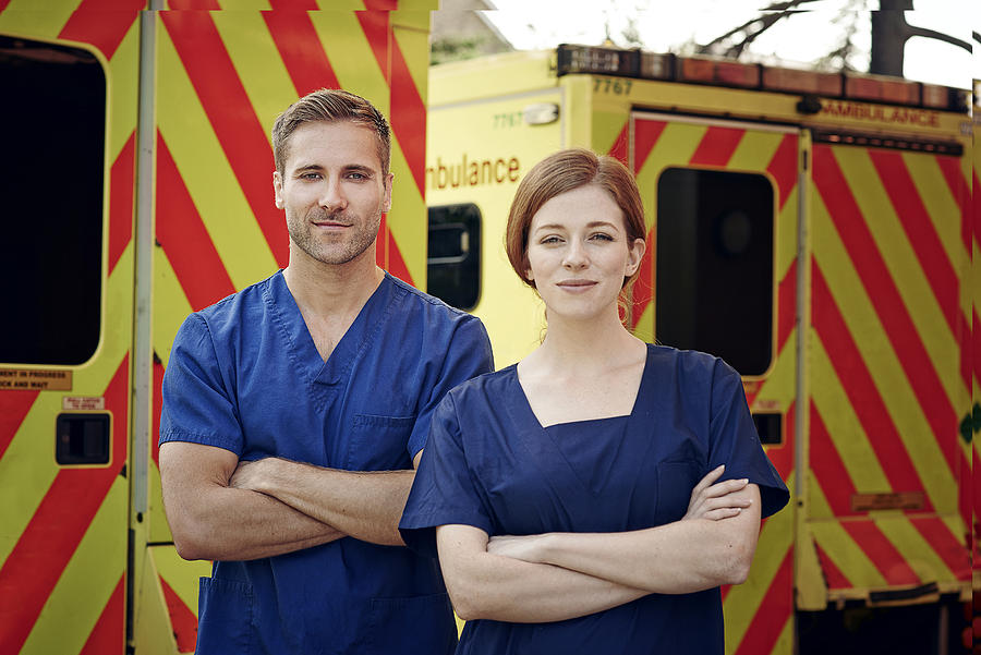 Portrait of two emergency medical technicians next to ambulance Photograph by Phil Fisk
