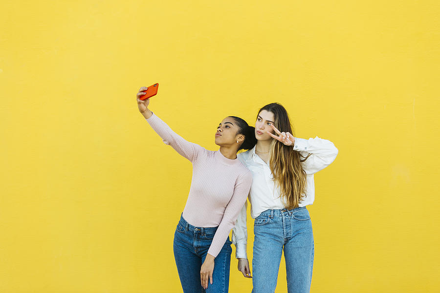 Portrait of two young girls taking a selfie Photograph by Jordi Salas
