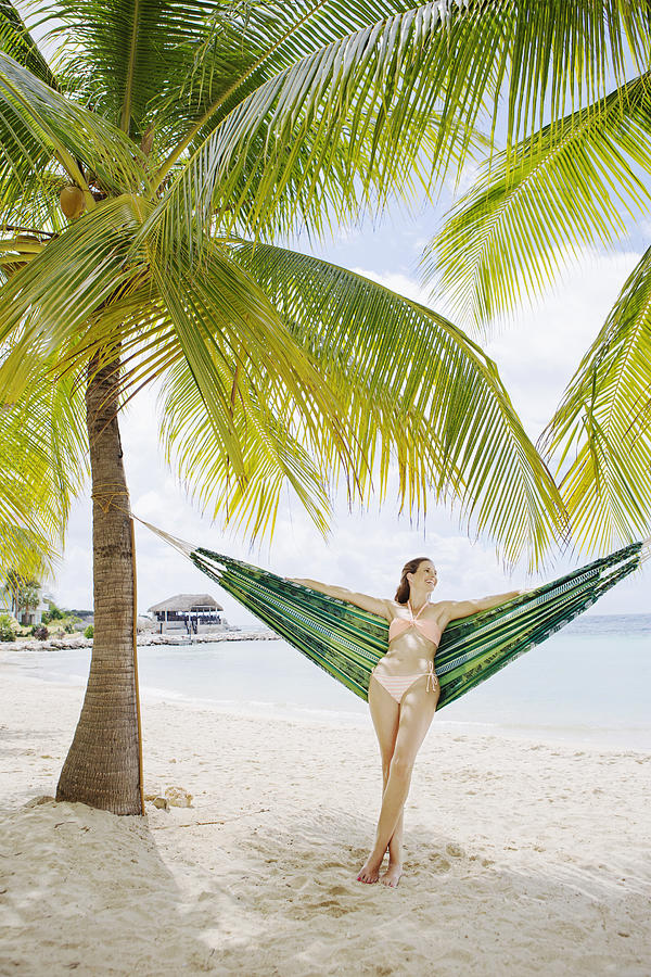Portrait of woman standing near hammock on beach Photograph by Felix Wirth