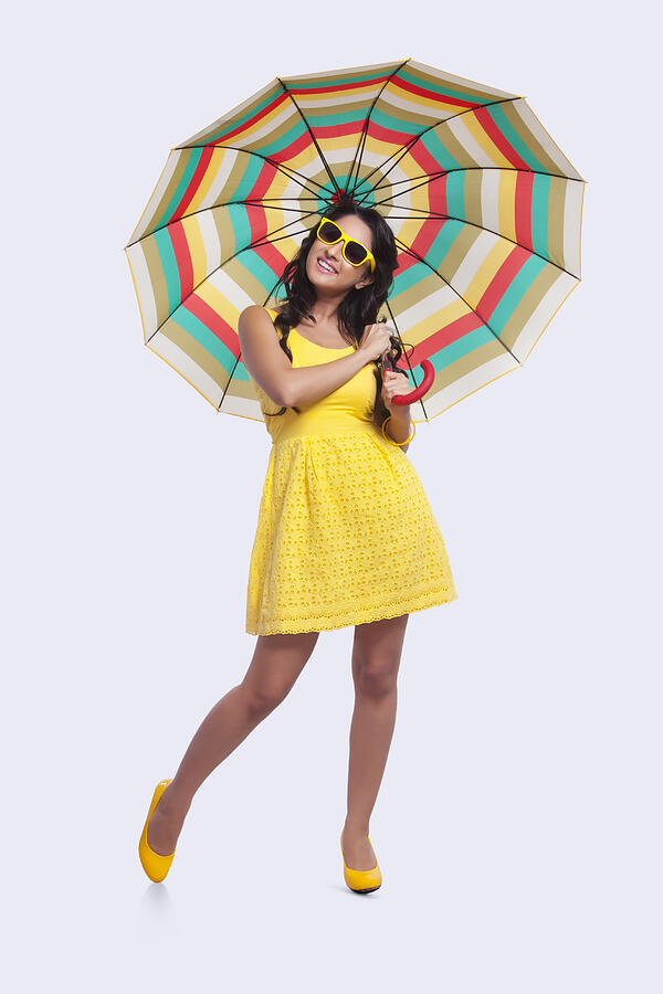 Portrait of woman with colourful umbrella Photograph by IndiaPix/IndiaPicture