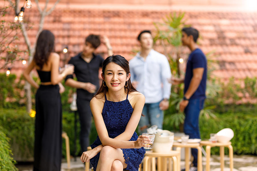 Portrait Of Young Asian Woman At Outdoor Roof Top Party With Friends Photograph by Thurtell