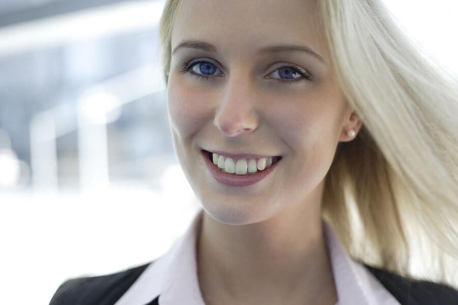 Portrait of young blonde woman smiling, head and shoulders Photograph by Peter Cade