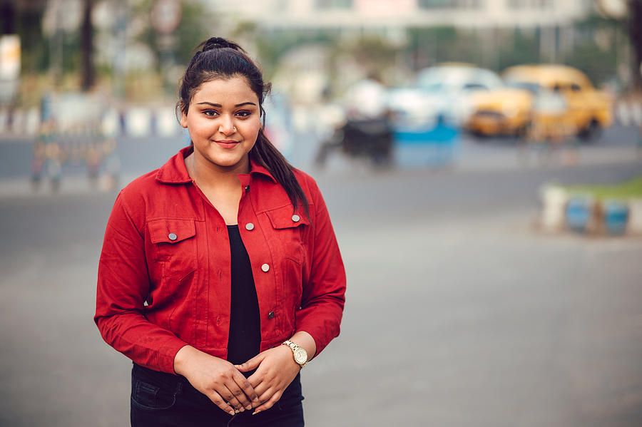 Portrait of young brunette Asian/ Indian girl wearing red denim shirt and smiling Photograph by Ankit Sah