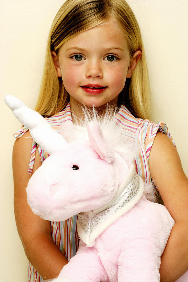 Portrait of young girl (4-5) with stuffed unicorn Photograph by Gallo Images-Hayley Baxter
