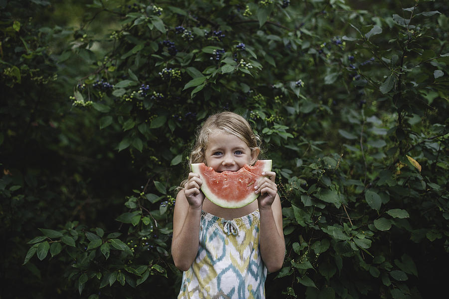 Portrait of young girl making a smiley face with melon slice Photograph by Cultura RM Exclusive/Erin Lester