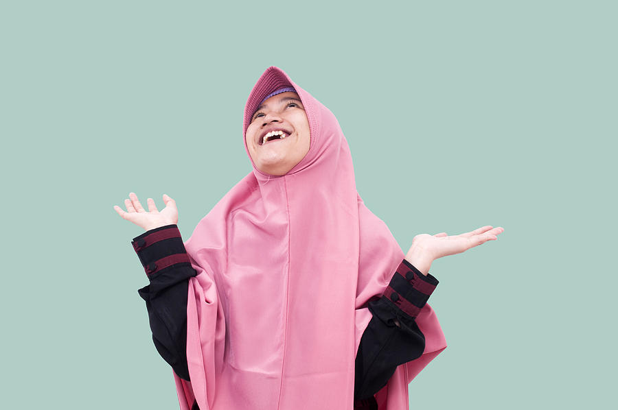 Portrait of young Happy muslim Woman raising her arms in front of Light blue background Photograph by Fajrul Islam