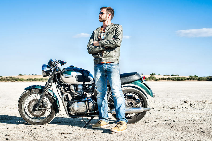 Portrait of young male motorcyclist on arid plain, Cagliari, Sardinia, Italy Photograph by Stefano Oppo