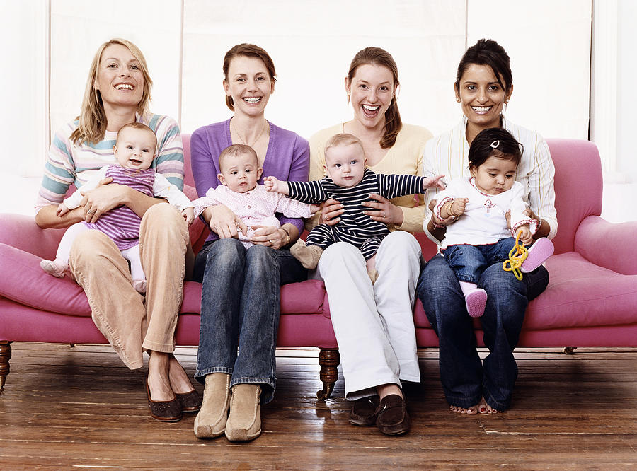 Portrait of Young Mothers with Their Children on a Sofa Photograph by Digital Vision.