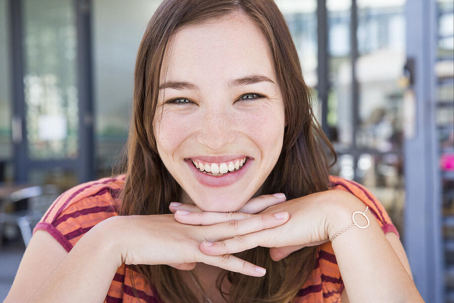 Portrait of young woman at coffee shop, laughing Photograph by Dimitri Otis