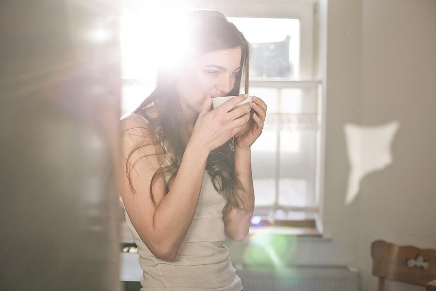Portrait of young woman drinking tea in the morning Photograph by Westend61