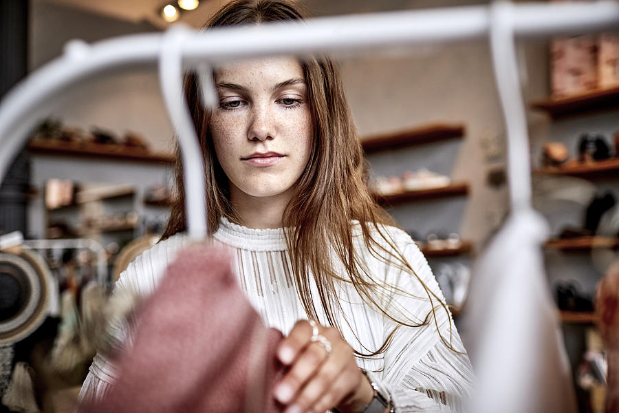 Portrait of young woman in a fashion store Photograph by Oliver Rossi