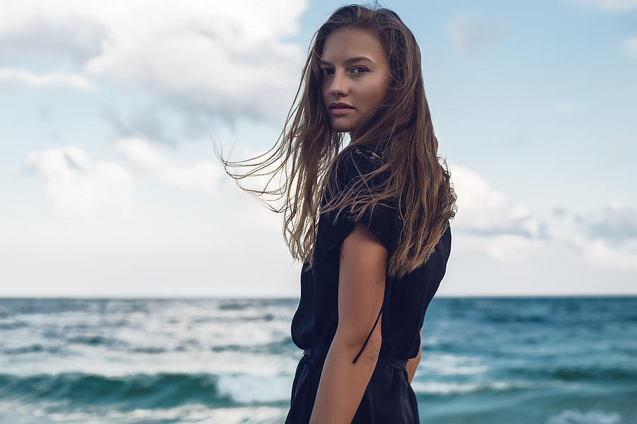 Portrait of young woman looking over her shoulder on beach, Odessa, Odessa Oblast, Ukraine Photograph by Rehulian Yevhen
