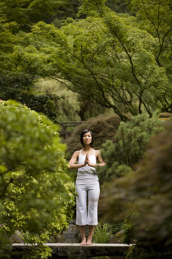 Portrait of young woman meditating on bridge in Japanese garden Photograph by John Giustina