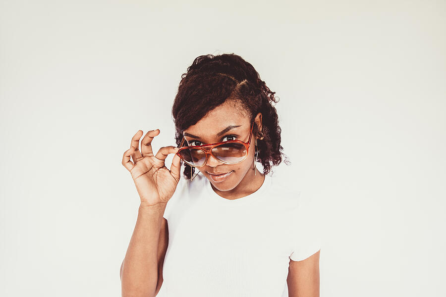 Portrait of young woman on white background wearing sunglasses Photograph by The Good Brigade