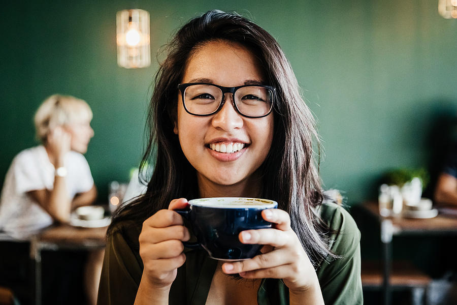 Portrait Of Young Woman Smiling Drinking Coffee Photograph by Tom Werner