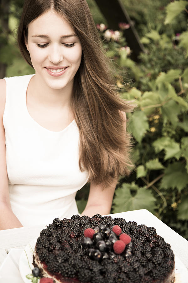 Portrait of young woman with chocolate berry cake Photograph by Westend61