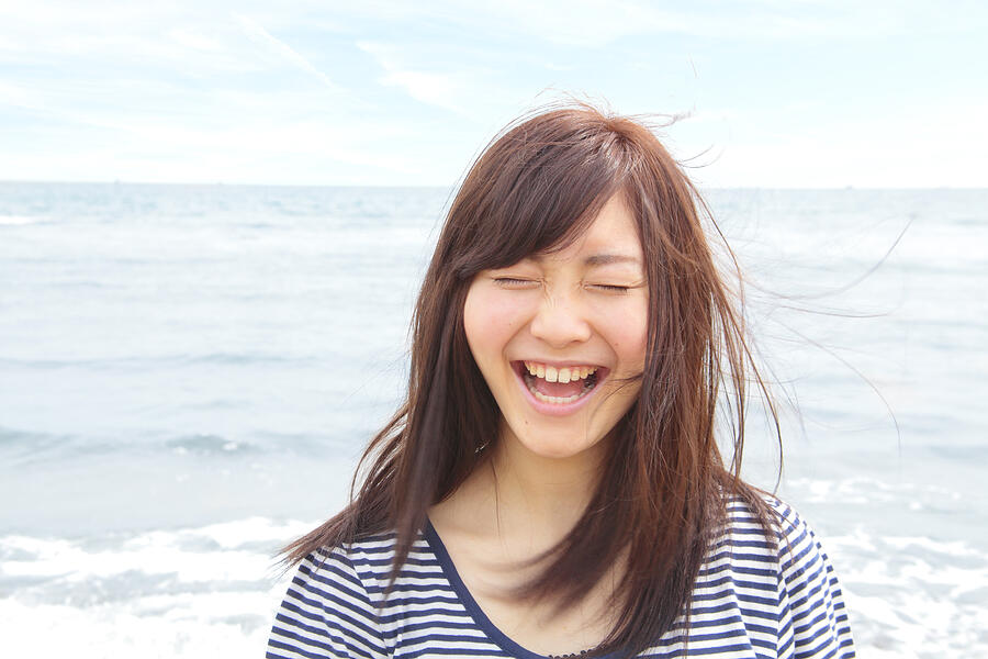 Portrait of young woman with eyes closed, laughing Photograph by Eri Takahashi