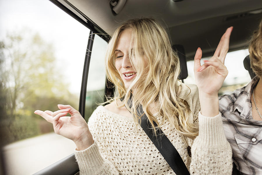 Portrait of young woman with eyes closed listening music in a car Photograph by Westend61