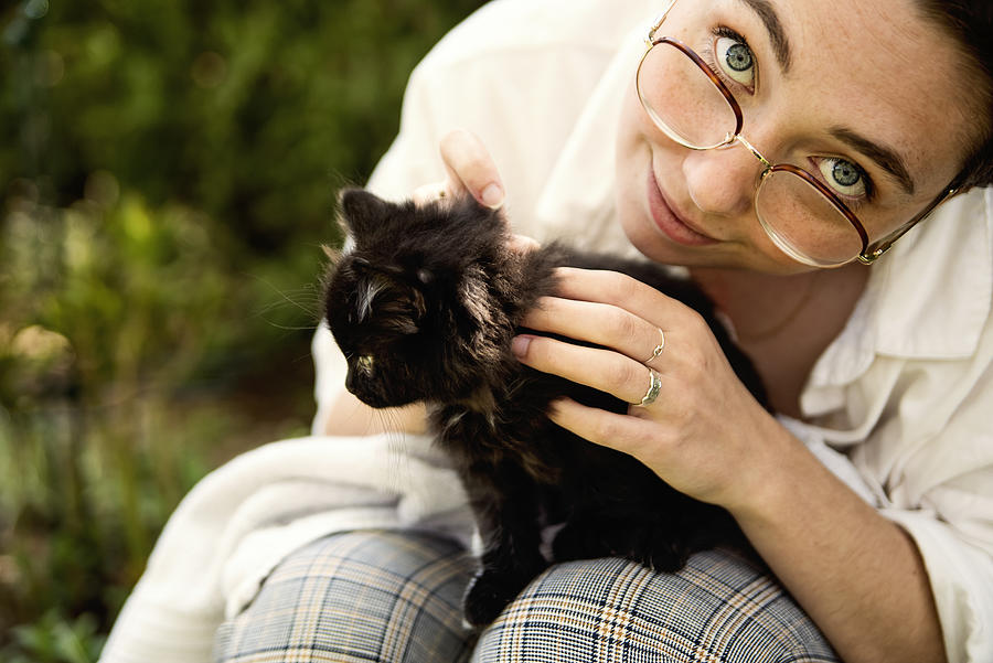Portrait of young woman with newly adopted kitten. Photograph by Martinedoucet