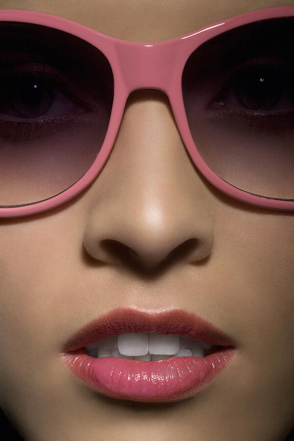 Portrait of young woman with sunglasses, close up. Photograph by Andreas Kuehn