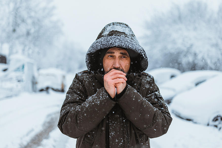 Portrait shot of the caucasian good looking mature man in casual style is freezing on the cold winter day while standing in the center city. Photograph by RealPeopleGroup Portrait shot of the caucasian good looking mature man in casual style is freezing on the cold winter day while standing in the center city. Photograph by RealPeopleGroup