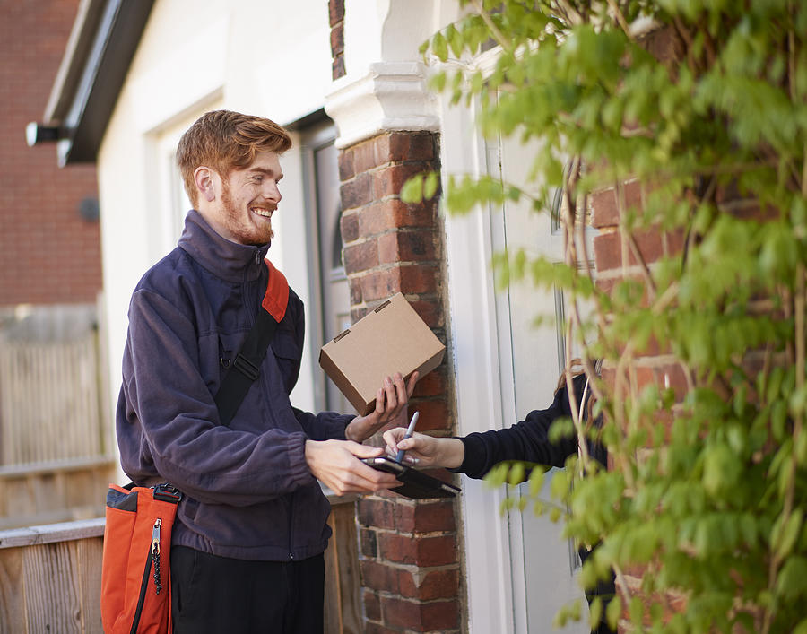 Postman delivering package to resident Photograph by Mike Harrington