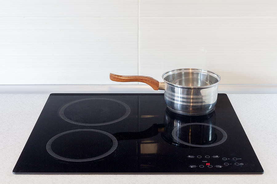 Pot in modern kitchen with induction stove Photograph by Brizmaker