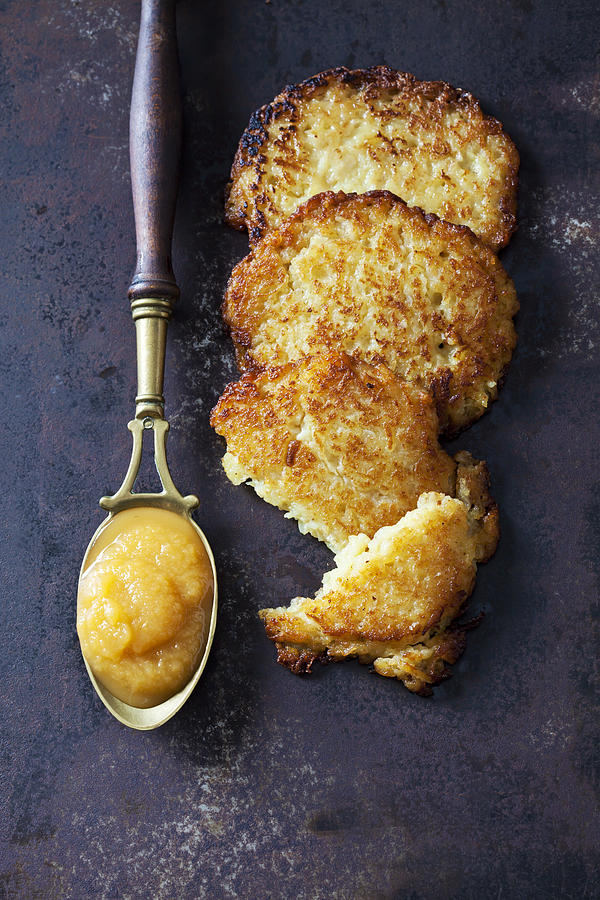 Potato fritters and spoon of apple sauce Photograph by Westend61