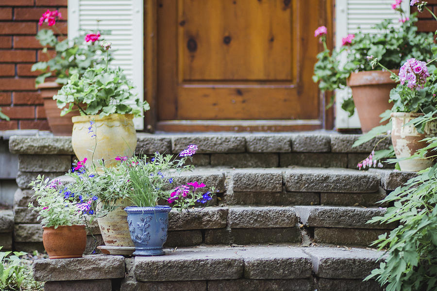 Potted plants with flowers on the steps of a house porch Photograph by Linda Raymond
