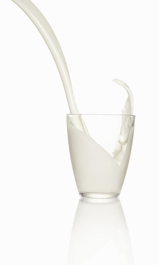 Pouring milk into a glass Photograph by StockFood
