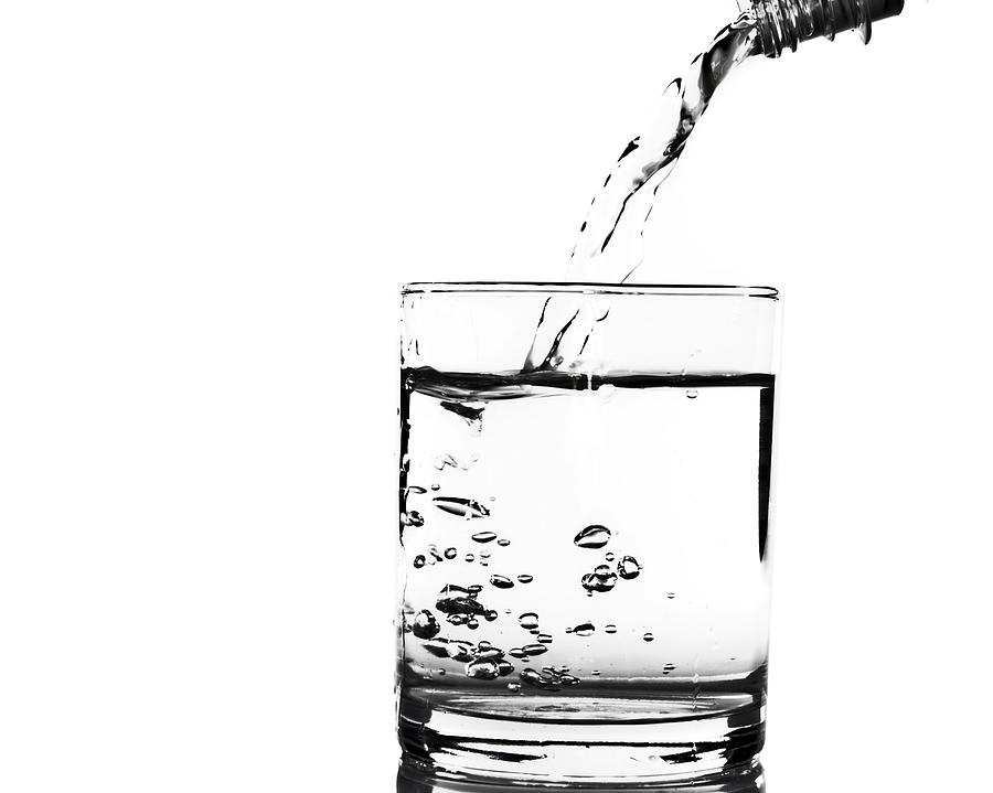 Pouring water into a glass on white Photograph by Deepblue4you