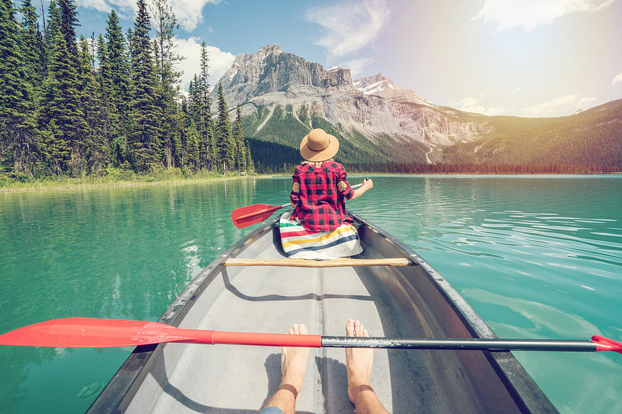 Pov of couple paddling red canoe on turquoise lake Photograph by Swissmediavision