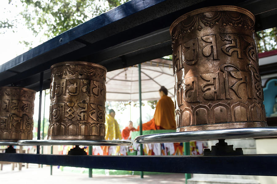 Prayer wheels also known as Dhamma chakka pavattana sutta wheel of law against buddha in preaching mode with his disciples at Sarnath at the sacred Buddhist pilgrimage site, Uttar Pradesh, India Photograph by Arpan Bhatia