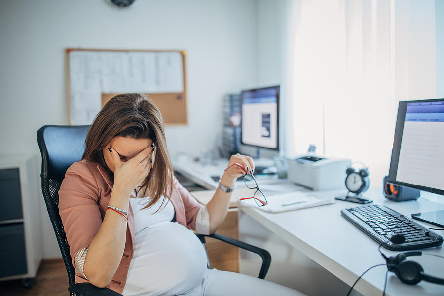 Pregnant businesswoman having headache Photograph by Hirurg