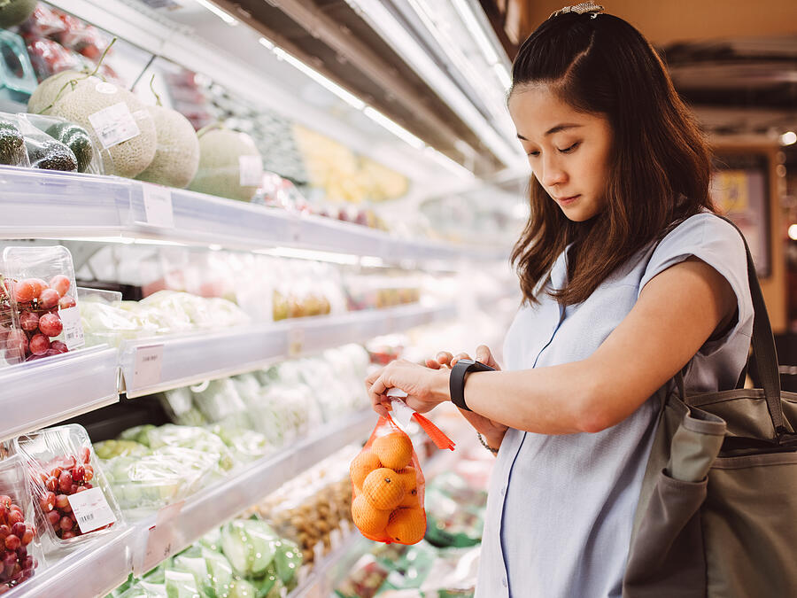 Pregnant mom using smart watch in supermarket Photograph by Images By Tang Ming Tung Pregnant mom using smart watch in supermarket Photograph by Images By Tang Ming Tung
