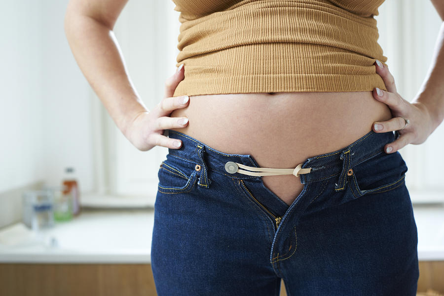 Pregnant Woman Bursting Out Of Jeans Photograph by Paul Viant