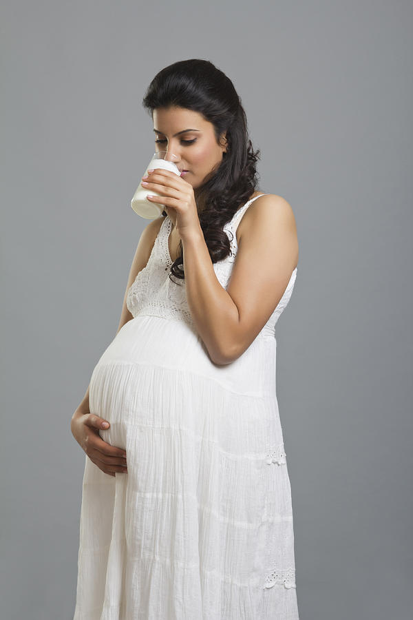 Pregnant woman drinking a glass of milk Photograph by IndiaPix/IndiaPicture