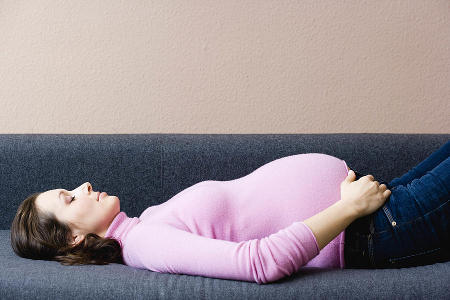 Pregnant woman laying on couch Photograph by Brigitte Sporrer