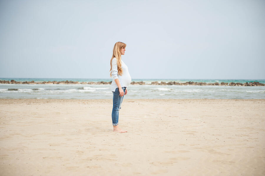 Pregnant woman on the beach. Casual clothes. Photograph by © Samantha Carrirolo