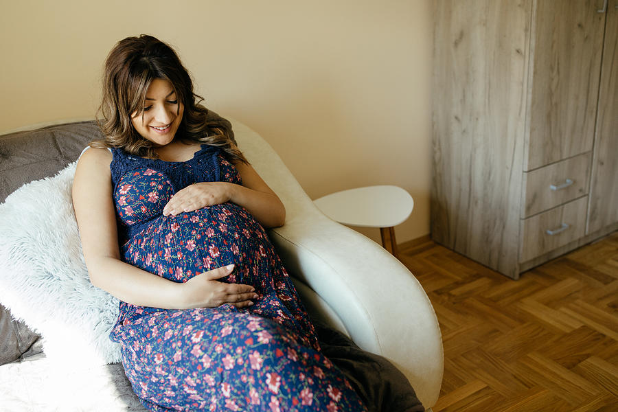 Pregnant woman resting at home Photograph by Bojanstory