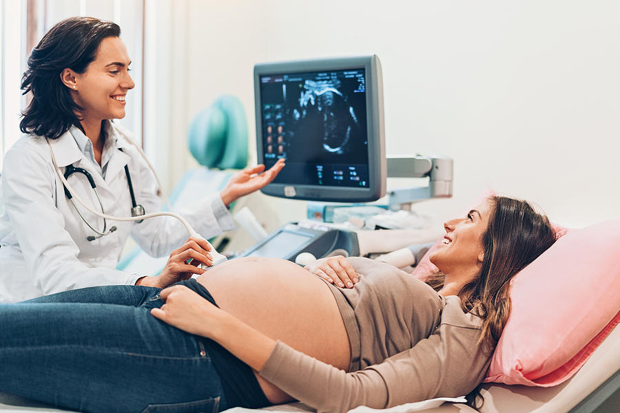 Pregnant woman watching her baby on the ultrasound Photograph by Pixelfit
