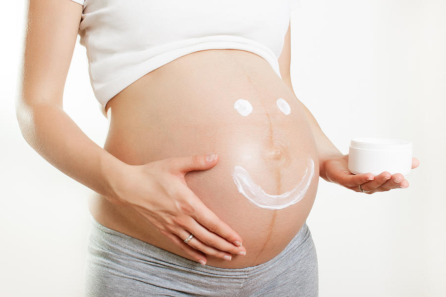 Pregnant woman with smile on her belly Photograph by Bogdankosanovic
