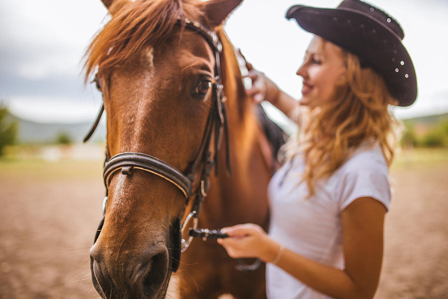 Pretty cowgirl with her horse Photograph by South_agency