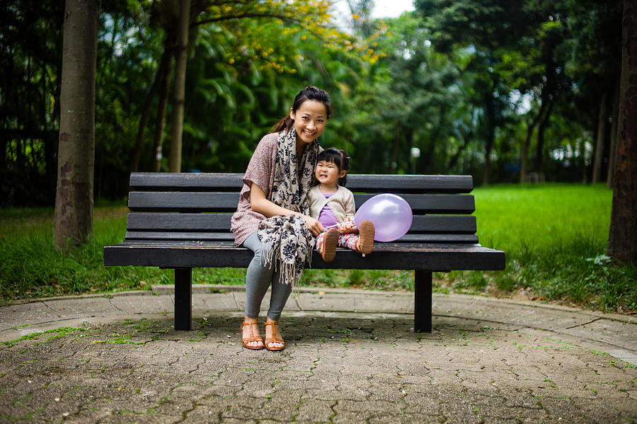 Pretty mom & toddler sitting on bench smiling Photograph by images by Tang Ming Tung