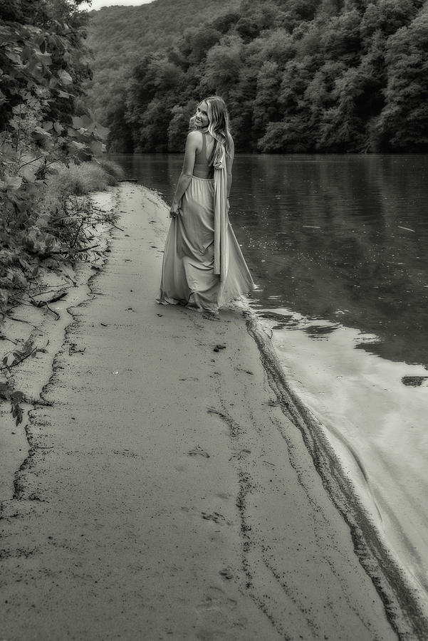 Pretty woman standing on shore on a lake black and white Photograph by Dan Friend