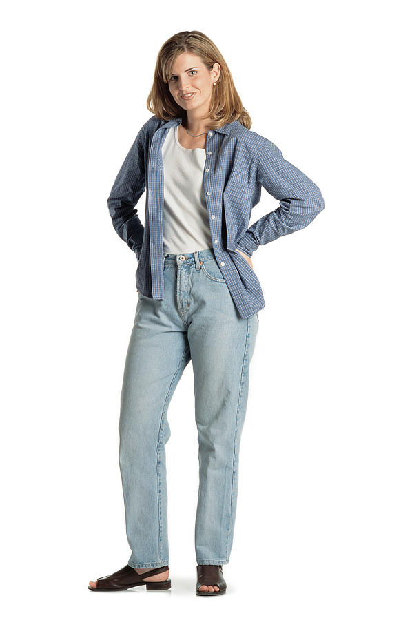 Pretty Young Caucasian Woman With Long Brown Hair Wearing A Blue Shirt Sandals And Blue Jeans Stands Smiling At The Camera With Her Hands On Her Hips And Smiles Photograph by Photodisc