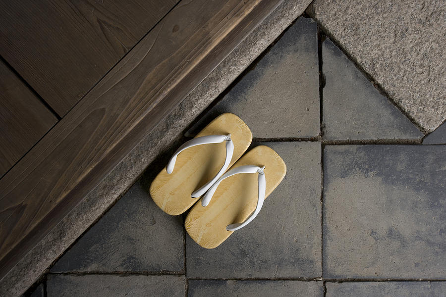 Priests slippers on stone tiles, close-up Photograph by B. Tanaka