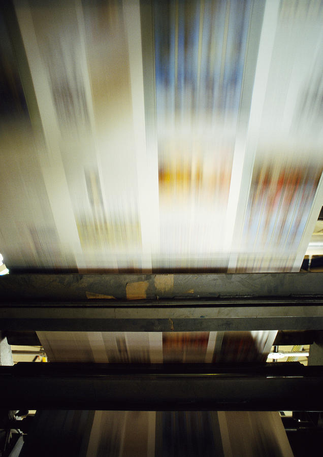 Printed paper on printing press, blurred motion Photograph by James Hardy