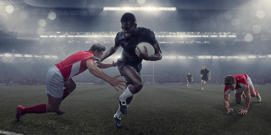 Pro Rugby Player Running With Ball Past Tackling Opponent Photograph by Peepo