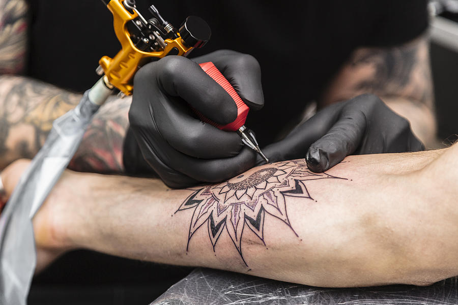 Process of creating tattoo in form of black flower Photograph by PaulGulea